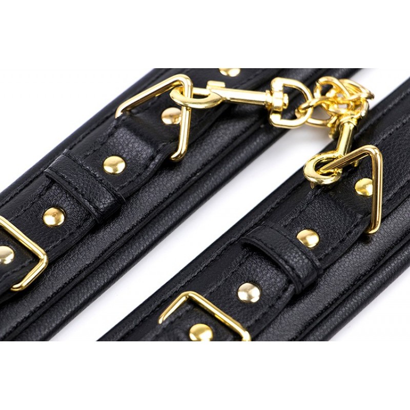 Черные кожаные наручники с золотистой цепочкой